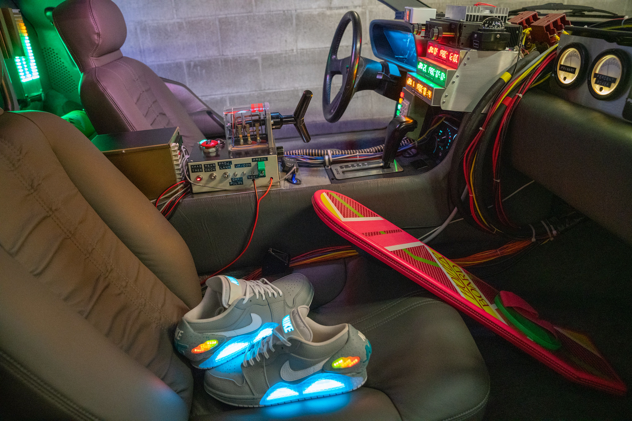 DeLorean 'Time Machine' replica interior: Time circuit switch and display, a hoverboard, and some custom Nike Air Jordan sneakers modified to include the blue 'Mag' cut-outs and heel caps similar to the sneakers in the second movie.