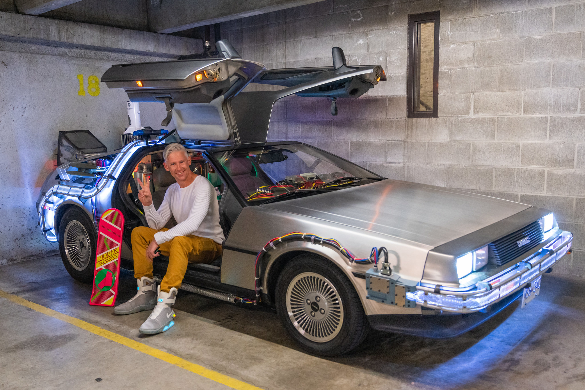 Scott with the DeLorean 'Time Machine' replica, with a hoverboard and replica Nike 'Air Mag' shoes.